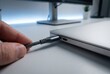 © Stitch - A person's hand plugging a braided USB-C cable into the port of a modern laptop.