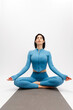 © wedmoments.stock - Sporty woman meditating in lotus pose on white isolated background. Wellness, mindfulness and healthy lifestyle concept.