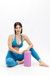 © wedmoments.stock - Fit woman in sportswear posing on exercise mat with foam roller. Fitness, wellness and body care concept.