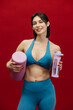 © wedmoments.stock - Athletic woman holding water bottle and foam roller. Workout, fitness and healthy lifestyle concept.