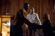© Boris Jovanovic/Stocksy - Colleagues exchanging handshakes in the amphitheater