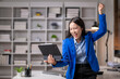 © Wasana - Excited businesswoman celebrating success with tablet