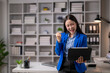 © Wasana - Successful businesswoman celebrating with tablet in office
