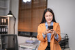 © Wasana - Young professional engaging with smartphone in office