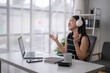 © Wasana - Young woman enjoying music while working remotely