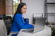 © Wasana - Asian businesswoman working on laptop in modern office