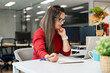 © Santi Nuñez/Stocksy - Woman working with laptop in modern office