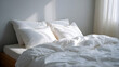 © MonkeyZ - Fresh White Bedding with Pillows and Blanket in a Simple Bedroom