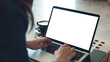 © tippapatt - Laptop computer blank screen mockup. Woman working on laptop with empty screen for advertising, contact business search information on desk at coffee shop. marketing and web design template