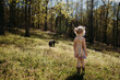 © Cavan Images - Child exploring spring forest meadow with dog