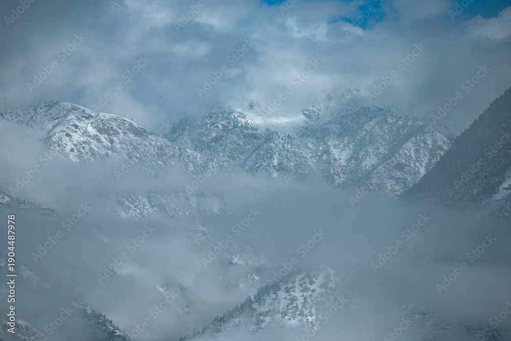 Clouds over snow covered mountains Stock Photo | Adobe Stock
