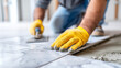 © Olha Havelia - Close-up of faceless hands in nitrile gloves applying a thin layer of back-buttering adhesive to the back of a marble tile, Professional Tiling Techniques, focus on the trowel and