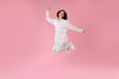 © New Africa - Beautiful woman in stylish pajamas jumping on pink background