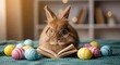 © Khan - Cute rabbit reading book surrounded by colorful easter eggs on a cozy blanket