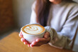 © Farknot Architect - Closeup image of a woman holding a cup of hot latte coffee