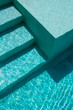 © José Grageda - Vista detallada de una piscina con agua turquesa cristalina y reflejos de luz natural sobre superficie arquitectónica moderna. Concepto de lujo, descanso, verano y estilo de vida relajado