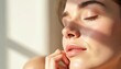© Maryna - Woman face with natural light and glow. Healthy skin texture shows moisture and freshness. Gentle touch on cheek suggests calm wellness routine. Appears radiant and confident.