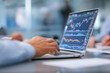 © Sajib - Close-up Hands Using Laptop with Financial Trading Graph