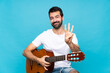 © luismolinero - Young man with guitar over isolated blue background happy and counting three with fingers