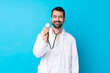 © luismolinero - Young caucasian man over isolated background wearing a doctor gown and with stethoscope