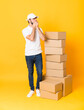 © luismolinero - Full-length shot of delivery man among boxes over isolated yellow background covering mouth and looking to the side