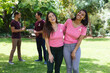 © wavebreak3 - Portrait of happy multiracial female friends wearing breast cancer awareness ribbons at park