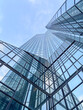 © Yang Diao  - Glass skyscraper with reflections under blue sky.