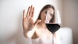 © fifthplanet - Young woman refusing a glass of wine with hand gesture. Female saying no to alcohol at social event.