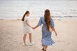 © svetograph - Beach Sisters Walking Summer: Two girls stroll hand-in-hand along sandy beach, enjoying summer day.