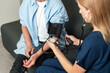 © brizmaker - Senior person receives blood pressure check during a doctor visit at home