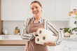 © Pixel-Shot - Young housewife with rolls of paper towels in kitchen