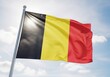 © RmGraphix - The belgian flag waving in the wind under a clear blue sky with white clouds