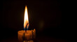 © Segera Studio - A close up of a lit wax candle showing the orange and blue flame with melted wax details
