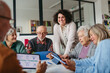 © Halfpoint - Tutor teaching seniors about phone scams and digital safety.