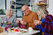 © Halfpoint - Group of senior people learning knitting together with caregiver tutor in a community center.
