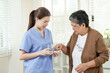 © Ekkasit A Siam - young asian female physiotherapist preparing to hand medication and glass of water to senior asian woman during rehabilitation therapy session in home clinic for elderly healthcare recovery support