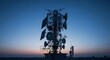 © Margarita Ratatosk - Communication tower with antennas and solar panels at twilight. Telecommunication infrastructure for network internet, 5G signal connection.