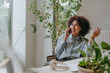 © Westend61 - Businesswoman smiling on the phone at a modern indoor office desk