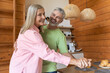 © zinkevych - Older adults moving playfully in kitchen setting