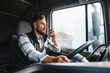© Serhii - Trucker communicating using radio while driving big rig