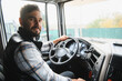 © Serhii - Truck driver sitting in cabin, transporting goods by road