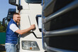 © Serhii - Happy driver smiling, patting new truck