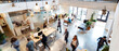 © petrrgoskov - Wide angle view of people working and walking inside a modern coworking space with open layout, natural light, motion blur and dynamic professional atmosphere.
