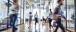 © petrrgoskov - Wide angle view of professionals walking through a modern consulting office with glass architecture, motion blur and dynamic corporate business environment.