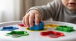 © Svyatoslav Lypynskyy - Child hand playing with colorful shape sorting toy