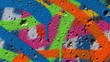© Marie art - Vibrant graffiti adorns a weathered concrete wall with abstract shapes and colors from a close-up view
