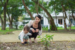 © leungchopan - Mother crouching with toddler exploring nature outdoors