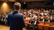 © Rahman - Speaker addressing a large audience at a business conference or seminar, delivering a presentation in an auditorium