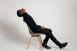 © Daniel Zapata/Stocksy - Man leaning on chair back