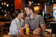 © Dusan Petkovic - Happy couple laughing together enjoying drinks at a restaurant